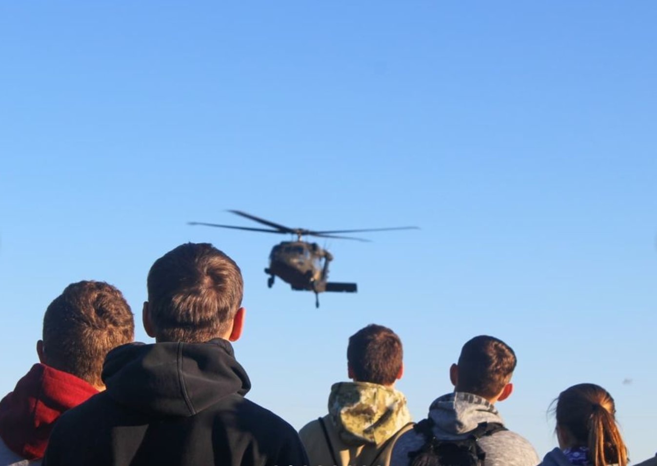 Cadets looking up at blackhawk flying