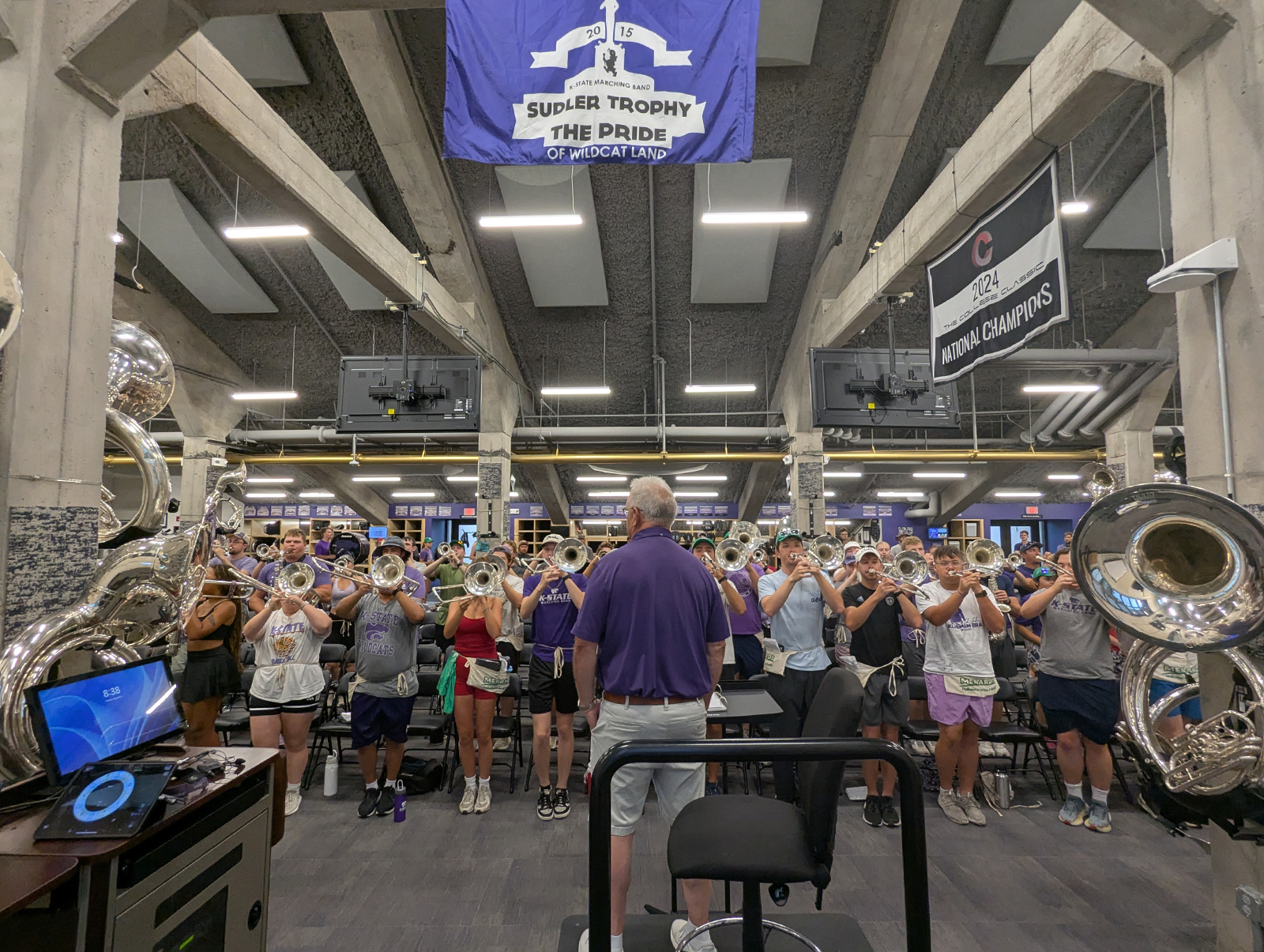 Frank Tracz stands with his hands and his pockets and his ears perked up as the marching band rehearses in front of him.
