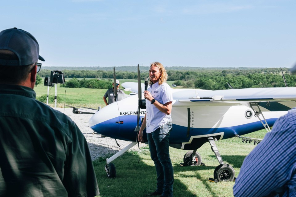 A young CEO gives a presentation to a large group of farmers, industry partners and other unmanned aerial systems stakeholders.