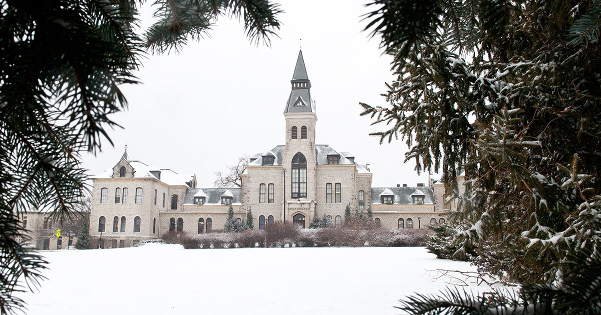 An exterior shot of Kansas State University's Anderson Hall shows its limestone tower under a blanket of snow.