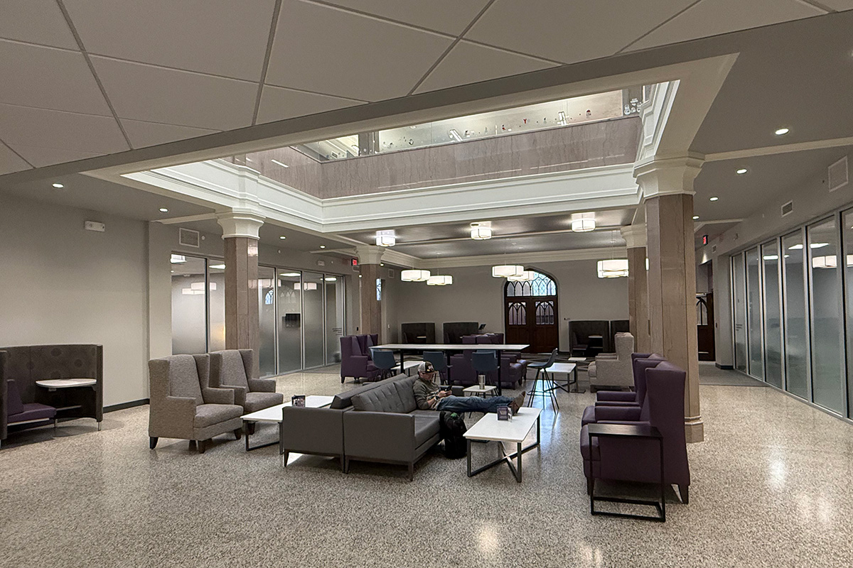 Student using a laptop in a renovated seating area inside Hale Library at Kansas State University.