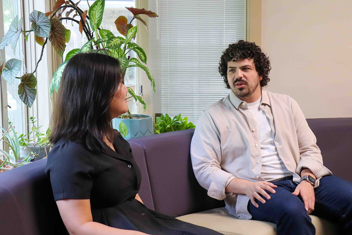 Two graduate researchers hold a conversations.