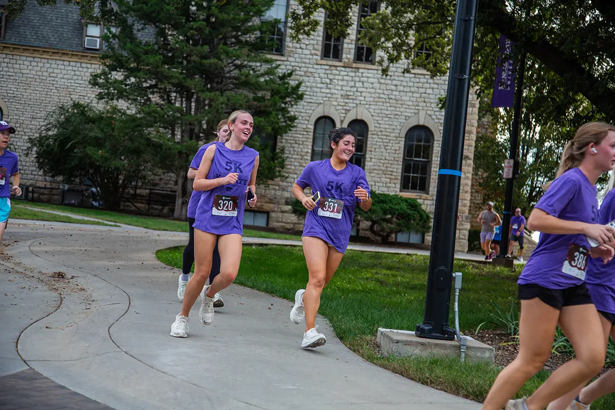 Two female students running on a scenic route.