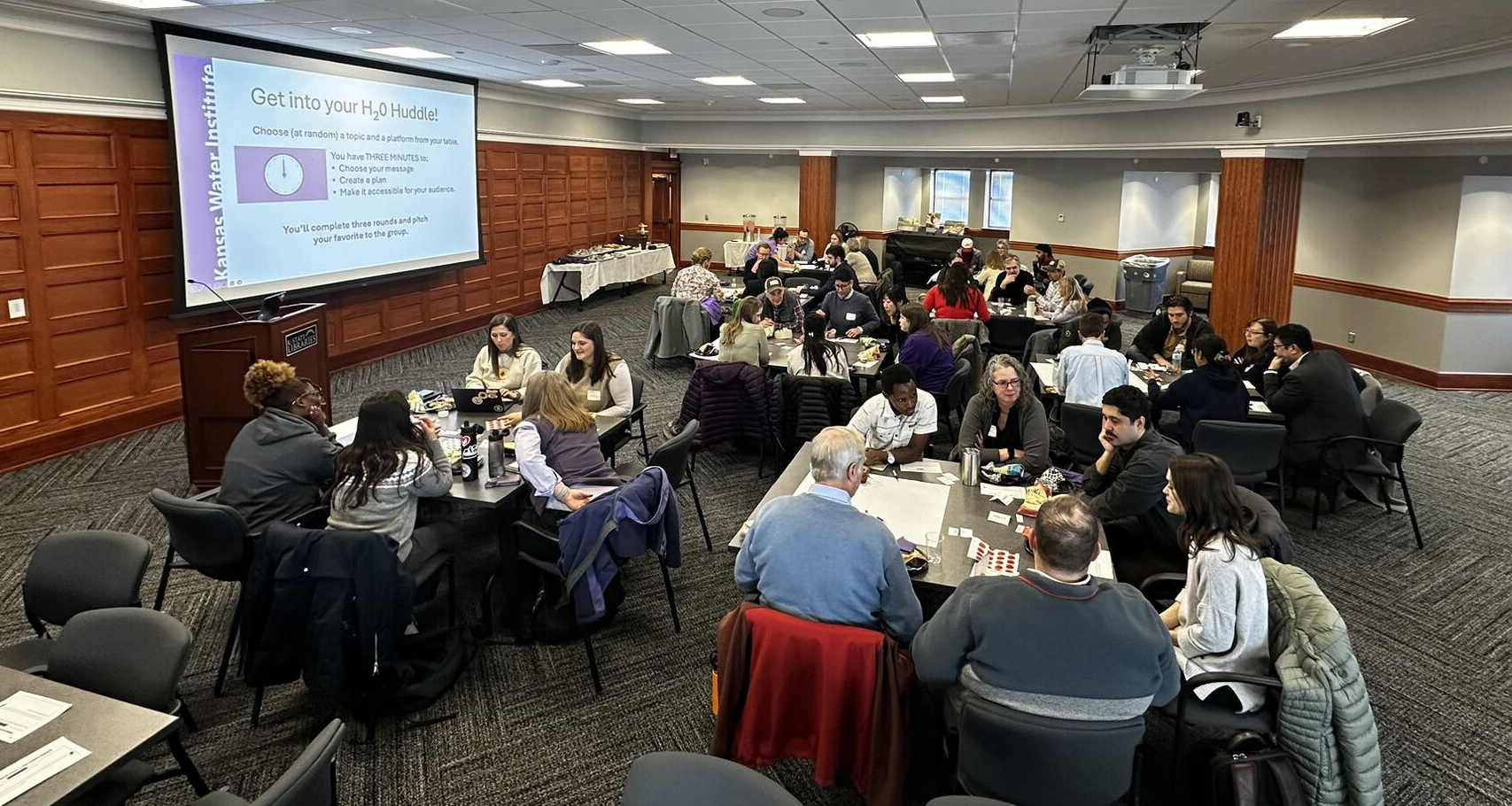 A group of people sitting at tables during a Water Wednesday workshop