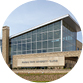 An exterior photo shows the outside of the glass-and-limestone K-State Olathe campus building.